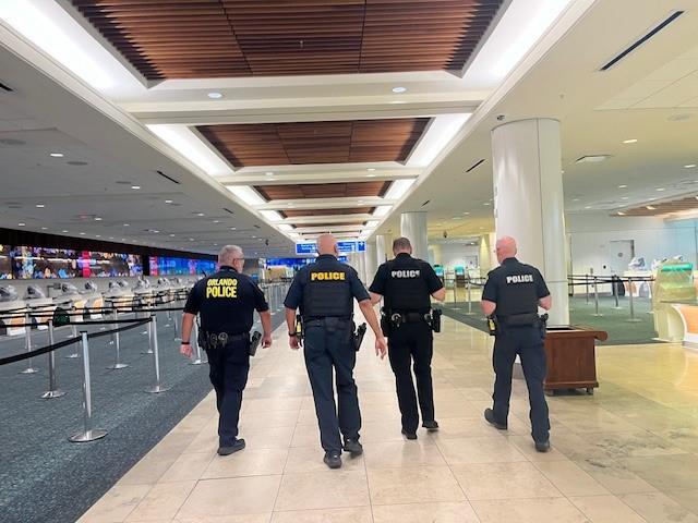 Law enforcement officers walk through Terminal A at Orlando International Airport shortly after the last passenger flight